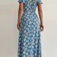 Robe d’été élégante à imprimé floral, manches courtes, épaules dénudées. Idéale pour les soirées et événements.