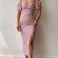Robe d’été élégante à imprimé floral, manches courtes, épaules dénudées. Idéale pour les soirées et événements.
