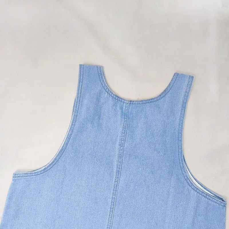 Robe en jean pour femme, sans manches, avec boutons sur le devant et deux poches pratiques. Confortable et légère, idéale pour l’été. Parfaite pour un look décontracté ou pour vos sorties quotidiennes.