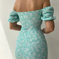 Robe d’été élégante à imprimé floral, manches courtes, épaules dénudées. Idéale pour les soirées et événements.