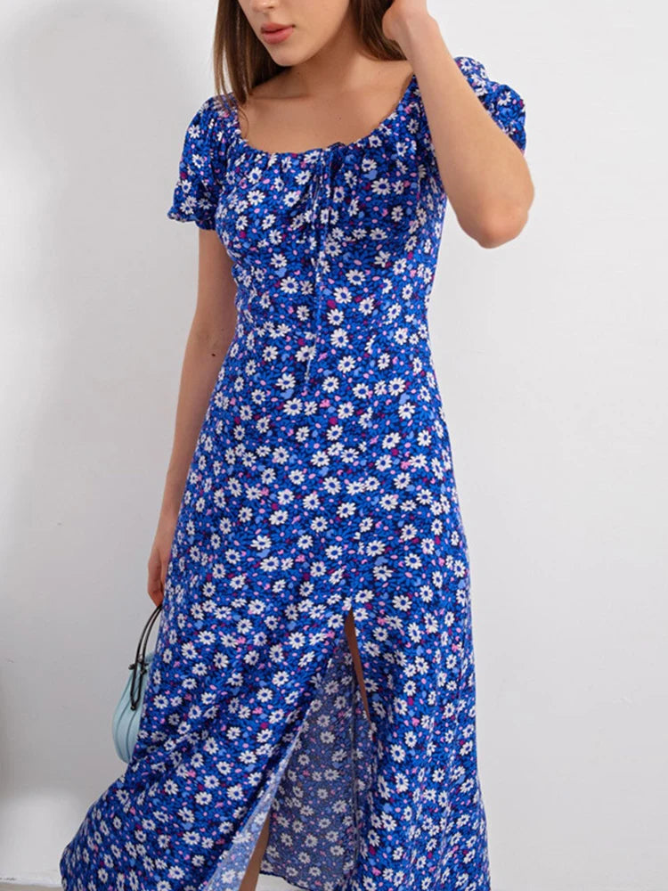 Robe d’été élégante à imprimé floral, manches courtes, épaules dénudées. Idéale pour les soirées et événements.